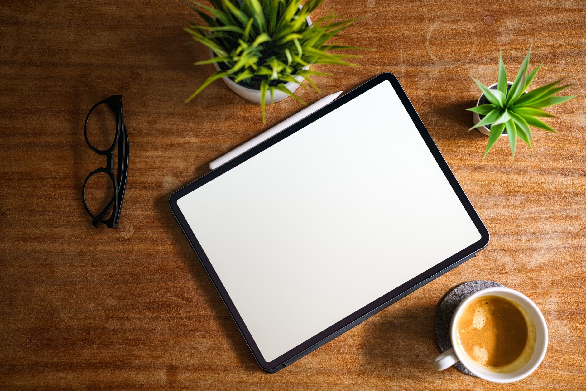 Tablet y café sobre mesa de madera — espacio de trabajo digital ordenado